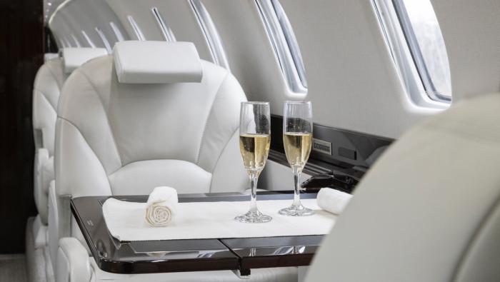 private jet interior with two glasses of champagne