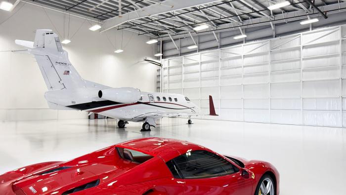 Private jet and Ferrari in private hangar