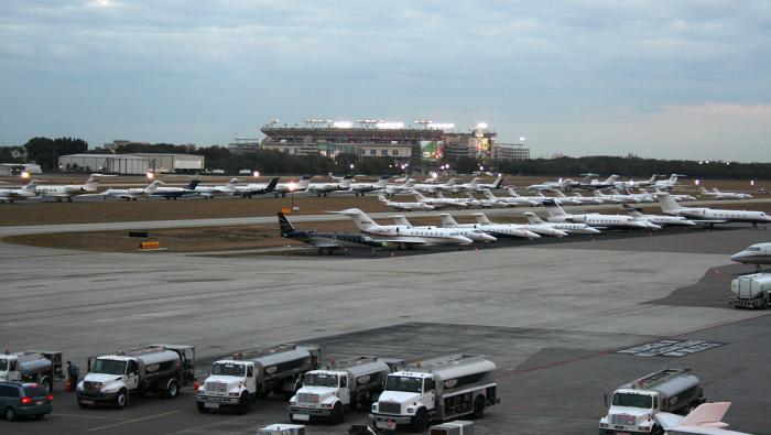 airport with parked jets and football stadium in background