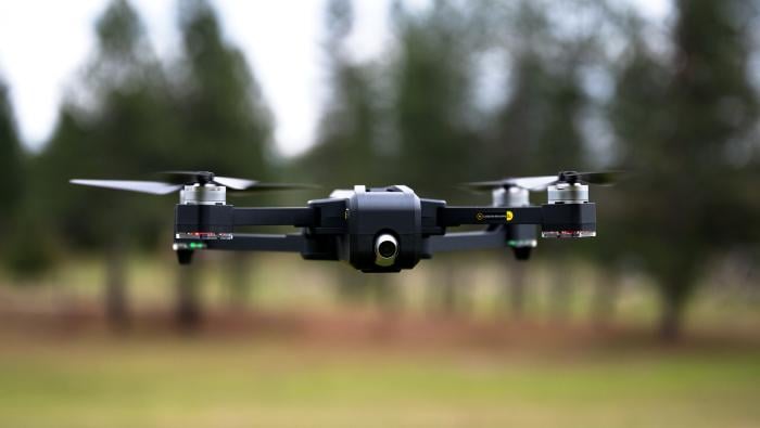 Small drone flying low over field 