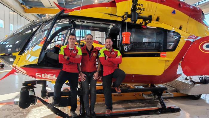 Crew members standing in front of H145-D3 in hangar 