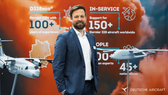 Fischer standing next to concept models of aircraft and drone 