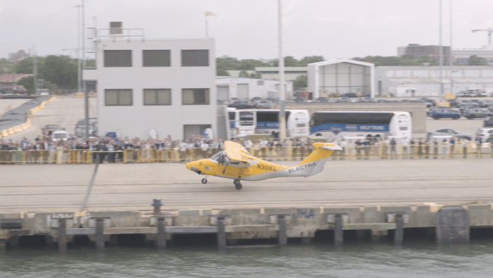 Electra EL2 landing on pier alongside crowd 