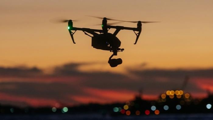 Drone flying over water at sunset 