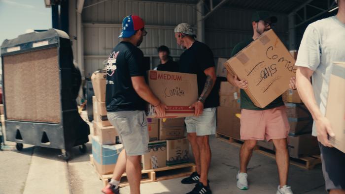 Volunteers pass boxes for a Hope on Wings mission