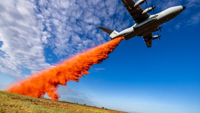 A400M flying low dropping orange retardant