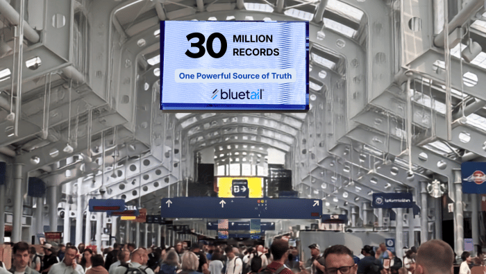 an airport terminal with a sign advertising Bluetail above the crowds