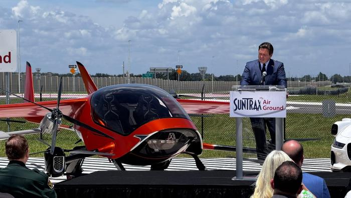 Ron DeSantis speaks beside the two-seat Air One eVTOL aircraft at SunTrax