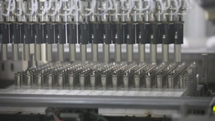 Rows of cylindrical battery cells on a production line