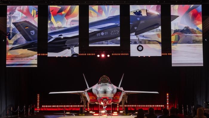 F-35 in hangar against graphics on screen 