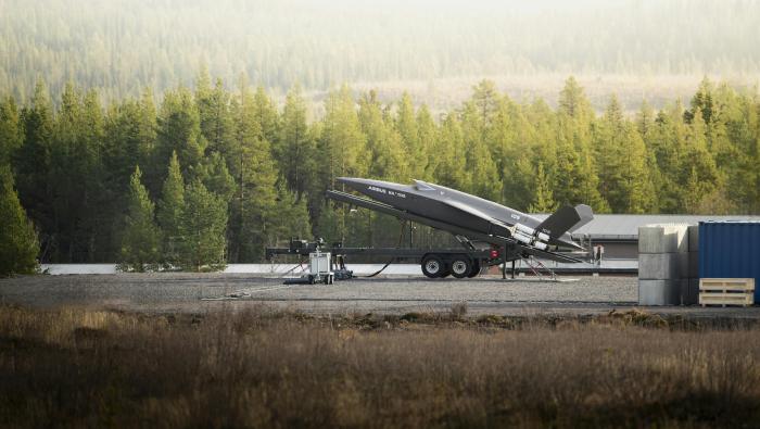 Drone mounted nose-up on ramp against forest background