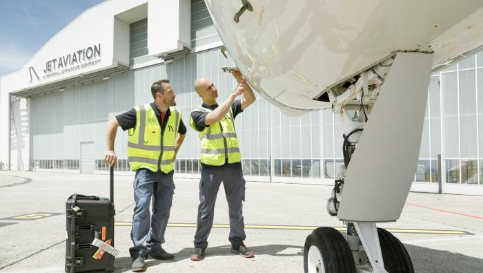 Jet Aviation techs examining aircraft outside hangar