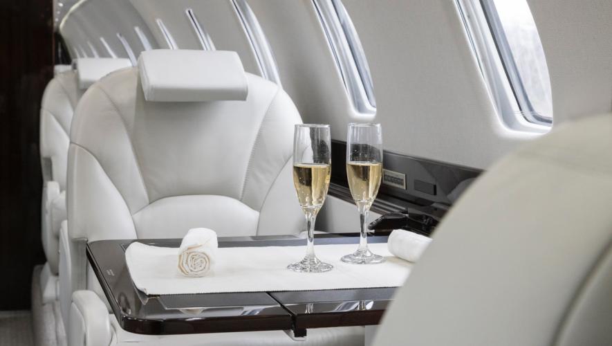 private jet interior with two glasses of champagne