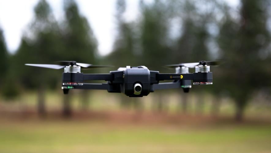 Small drone flying low over field 