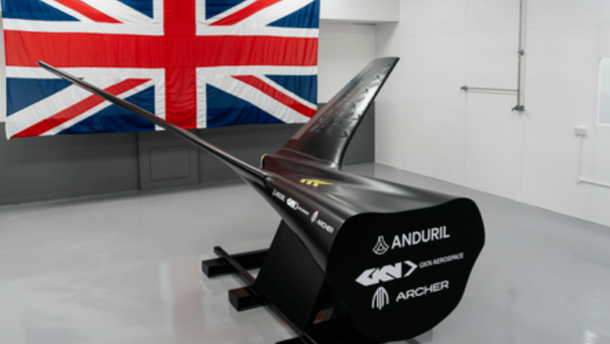 Mockup of tail and fuselage in front of Union Jack flag on wall 