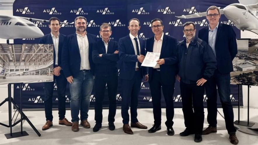 Aura Aero staff standing adjacent to model aircraft 