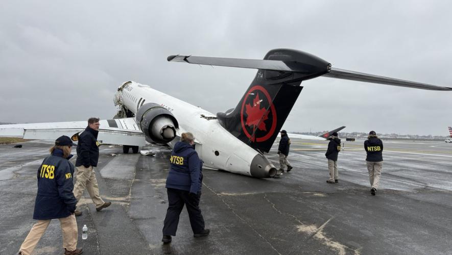 NTSB investigators walk the scene of the Mar. 22 collision between an Air Canada Express plane and a firefighting vehicle on Runway 4 at LaGuardia Airport.