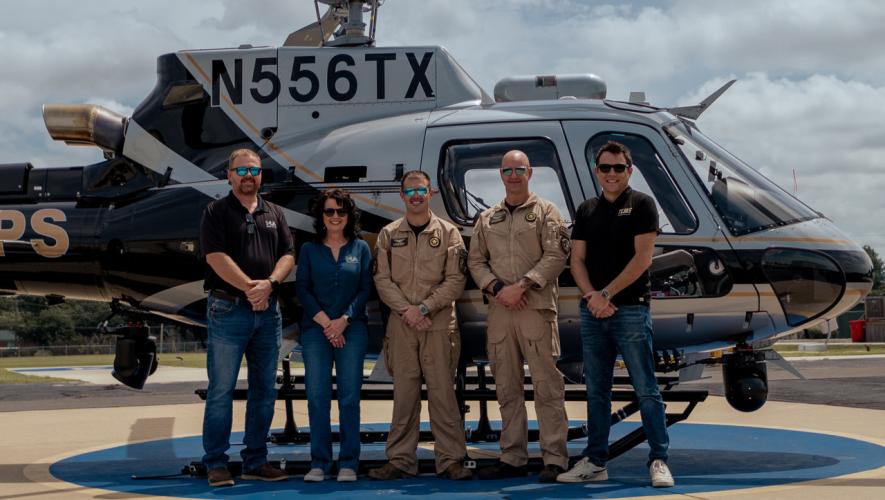 5 people standing by N-registered Airbus H125 