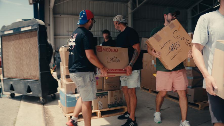 Volunteers pass boxes for a Hope on Wings mission