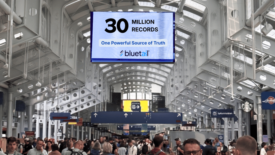 an airport terminal with a sign advertising Bluetail above the crowds