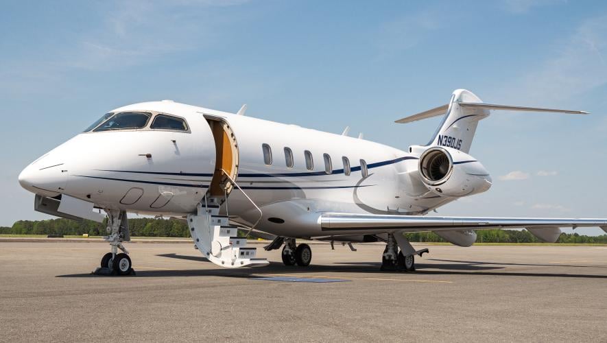 a jet parked on an airport ramp with the hatch open and stairs extended