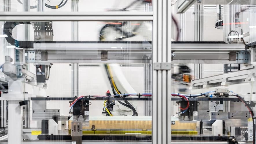 A robotic arm works inside an enclosed station on Archer’s battery pack production line