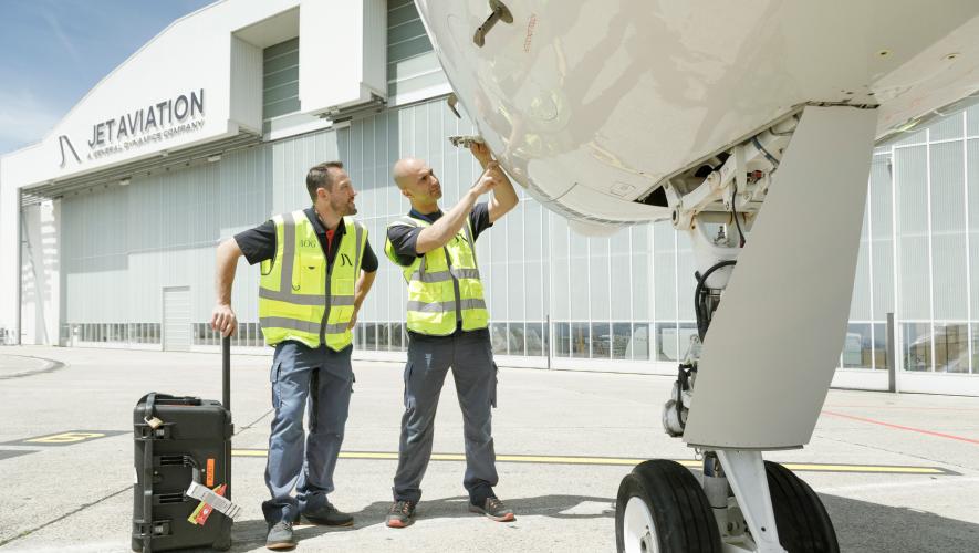Jet Aviation techs examining aircraft outside hangar