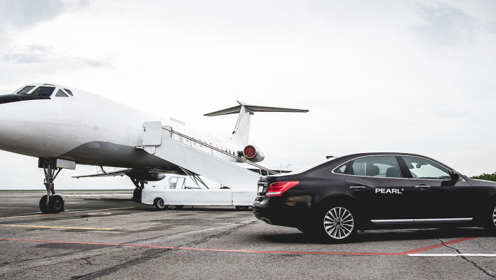 Pearl branded limousine next to private jet