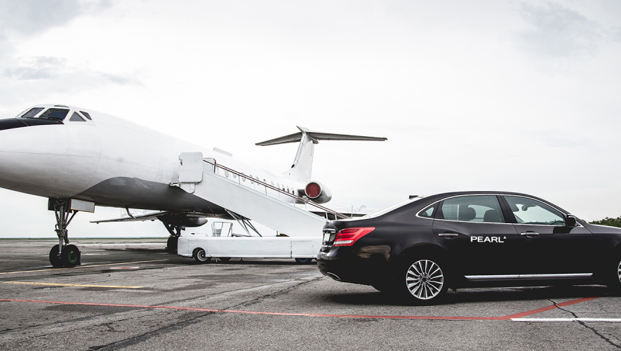 Pearl branded limousine next to private jet