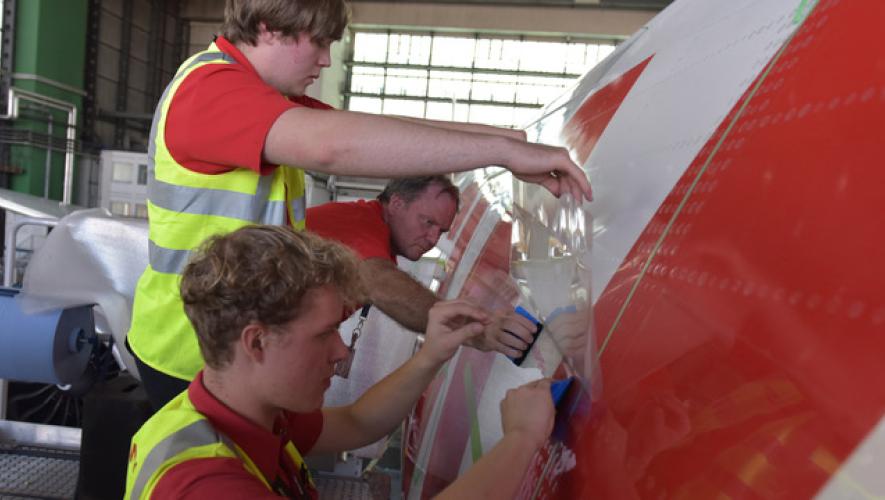 Swiss International Air Lines workers applying the AeroSHARK skin to the fuselage of a Swiss Boeing 777-300ER.