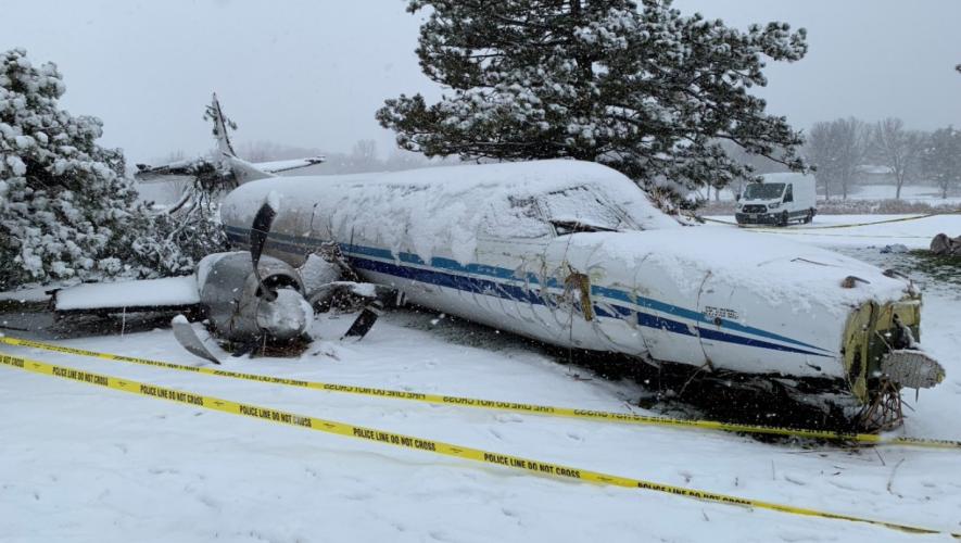 Crashed 1985 Fairchild Metro SA227 covered in snow and cordoned off with police and fire line caution tape