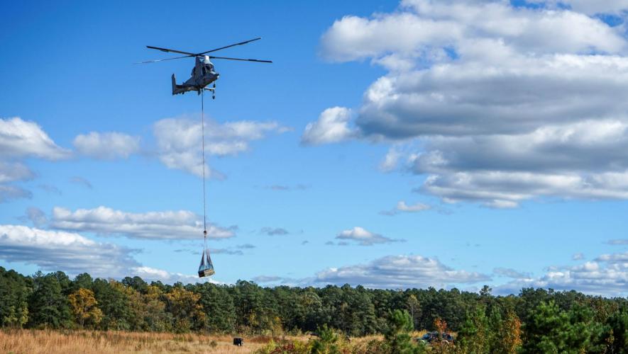 Kaman K-Max heavy-lift helicopter in flight carrying external load