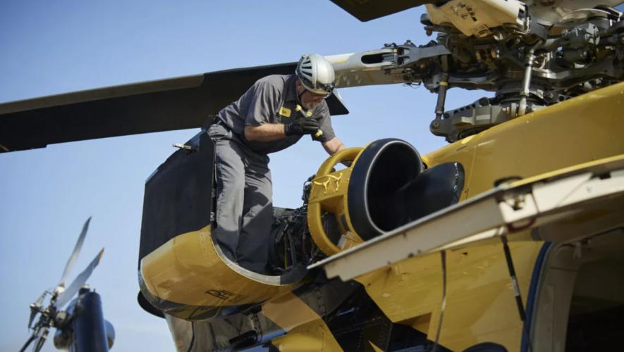 PHI MRO Services Tech inspecting engine on helicopter