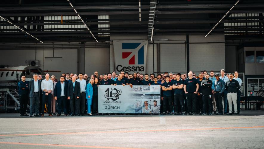 Textron Aviation team in hangar with banner celebrating 10th anniversary of Zurich service center