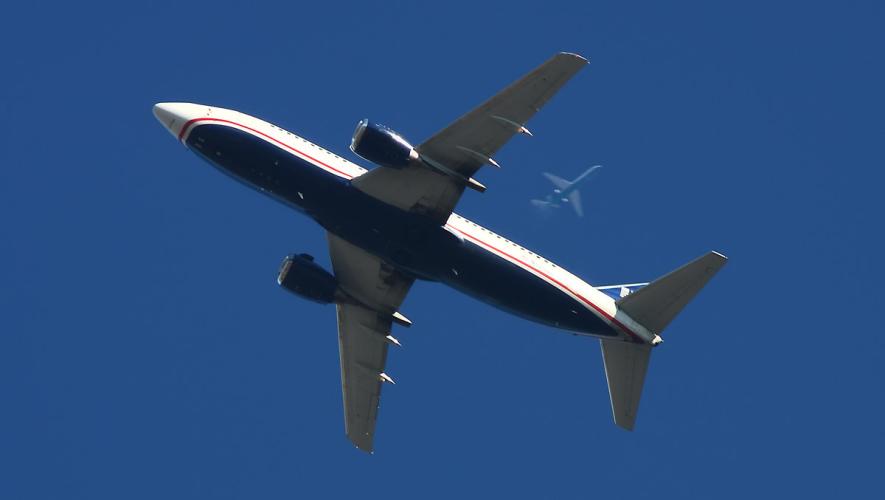 US Airways Boeing 737-300 in flight with another airliner overhead