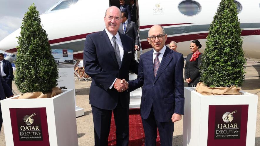 Gulfstream president Mark Burns (left) shakes hands with Qatar Airways CEO Akbar Al Baker at Paris Air Show static display with Gulfstream G700 business jet in background