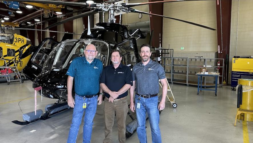Pictured from left to right: Tom Neumann, president of PHI MRO Services; John Byus, director of sales at GPMS; and Joshua Perkins, director of maintenance Part 145 in front of helicopters in PHI MRO hangar 