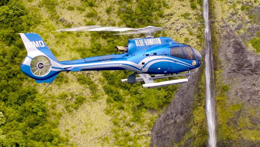 Blue Hawaiian Helicopter tour in flight near a waterfall in Hawaiian Islands