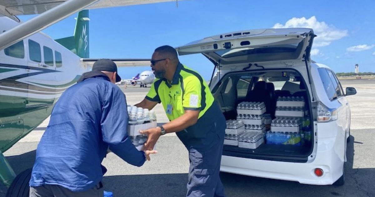 Atlantic Aviation staffer loads water on to relief flight
