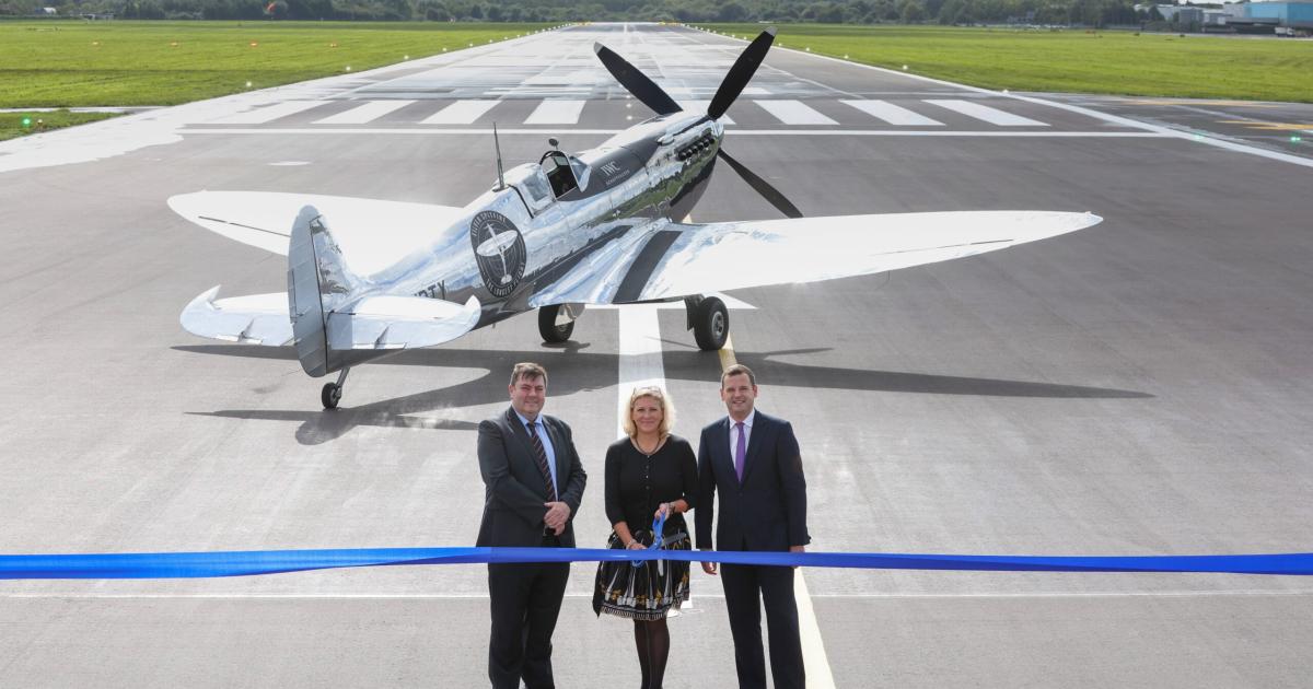 WWII-vintage Spitfire parked on newly-lengthened Southampton Airport runway with (left to right) operational director Steve Szalay, UK aviation minister Baroness Vere, and local Member of Parliament Paul Holmes. 