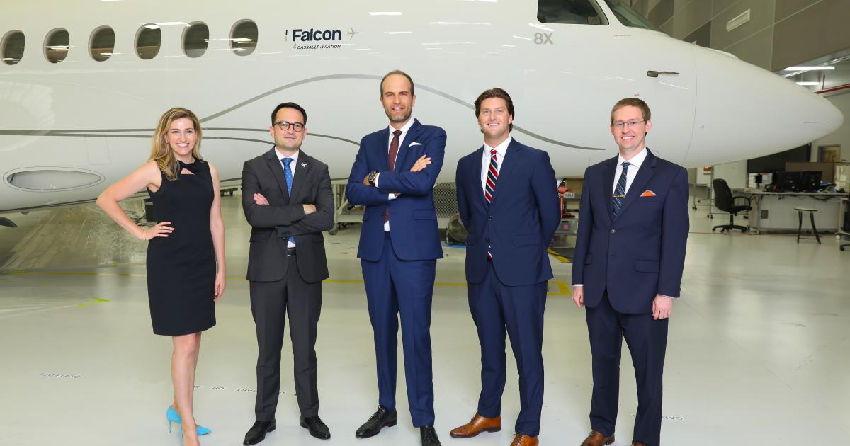 Dassault and AviationManuals executives pose in front of a Falcon 8X