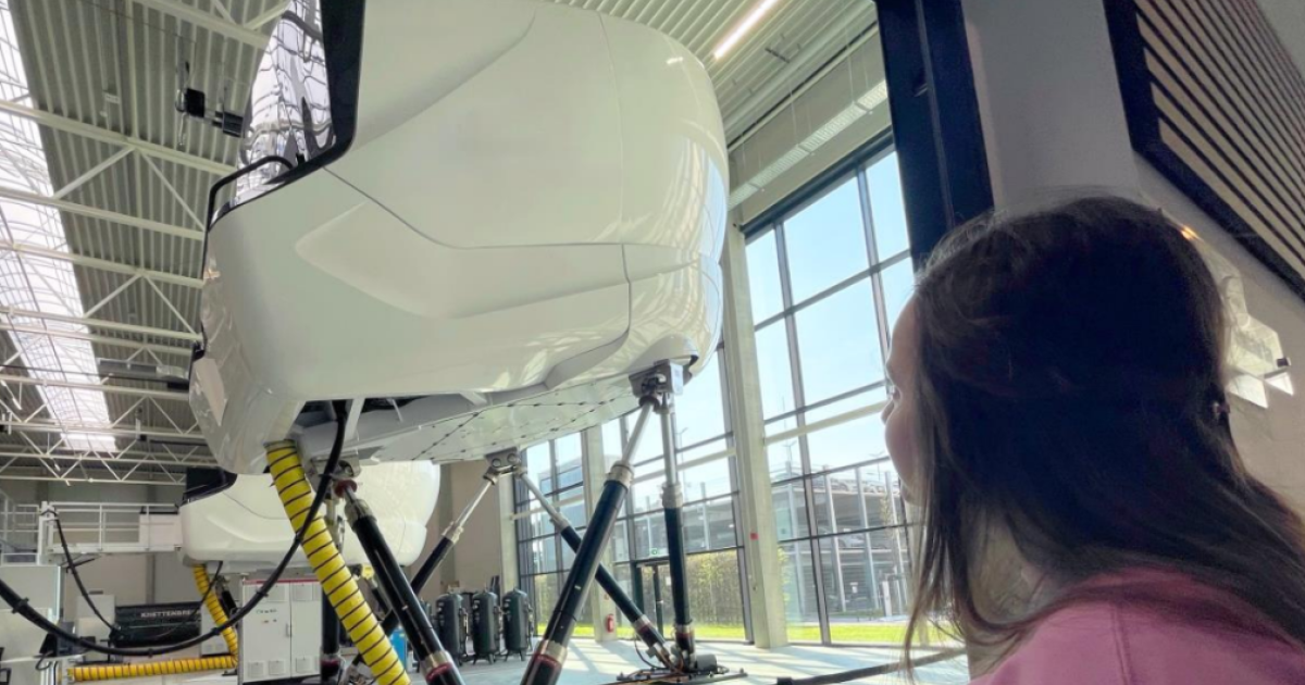 Girl looking at full-motion flight simulator 