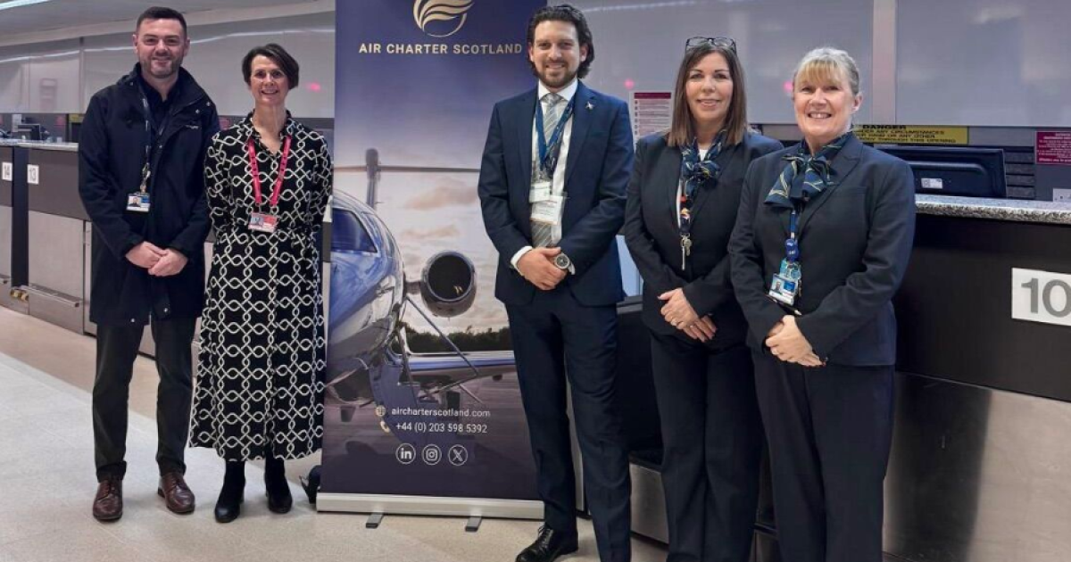 Crew at airport next to sign 
