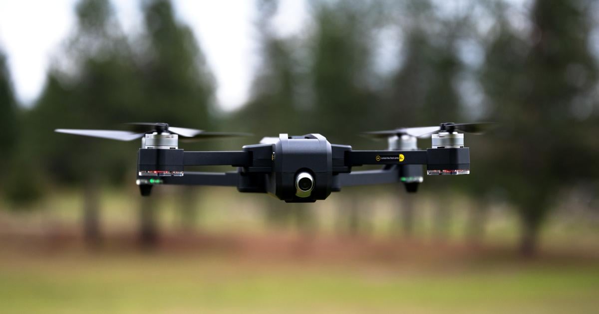 Small drone flying low over field 