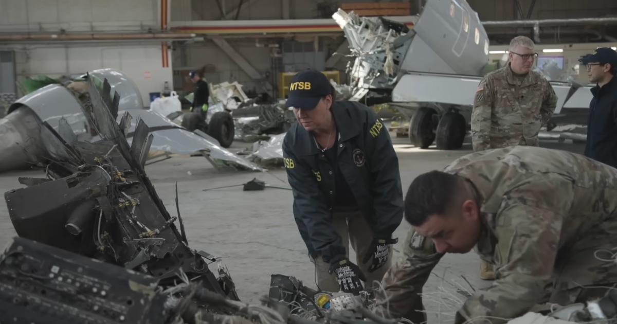 Investigators examining mid air collsion wreckage in Signature KDCA hangar