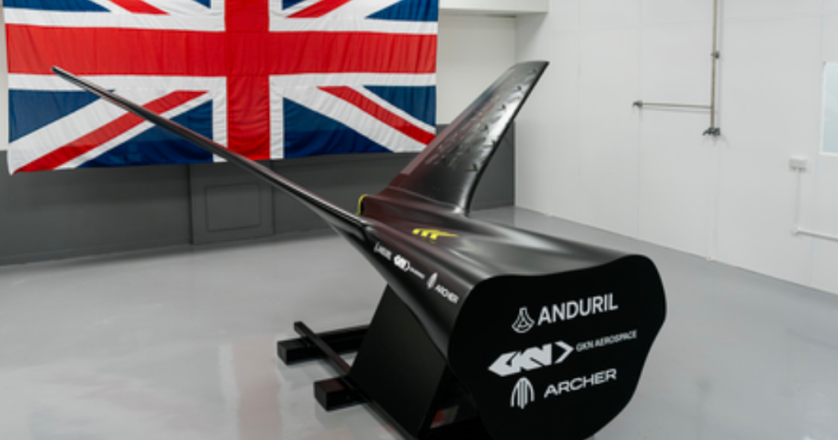 Mockup of tail and fuselage in front of Union Jack flag on wall 