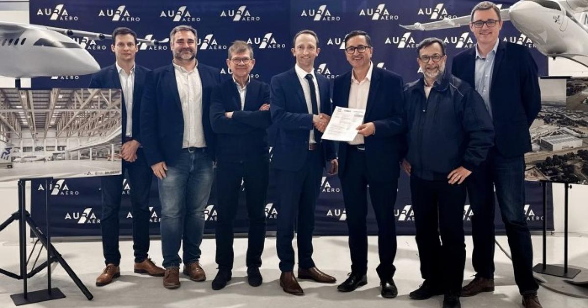 Aura Aero staff standing adjacent to model aircraft 