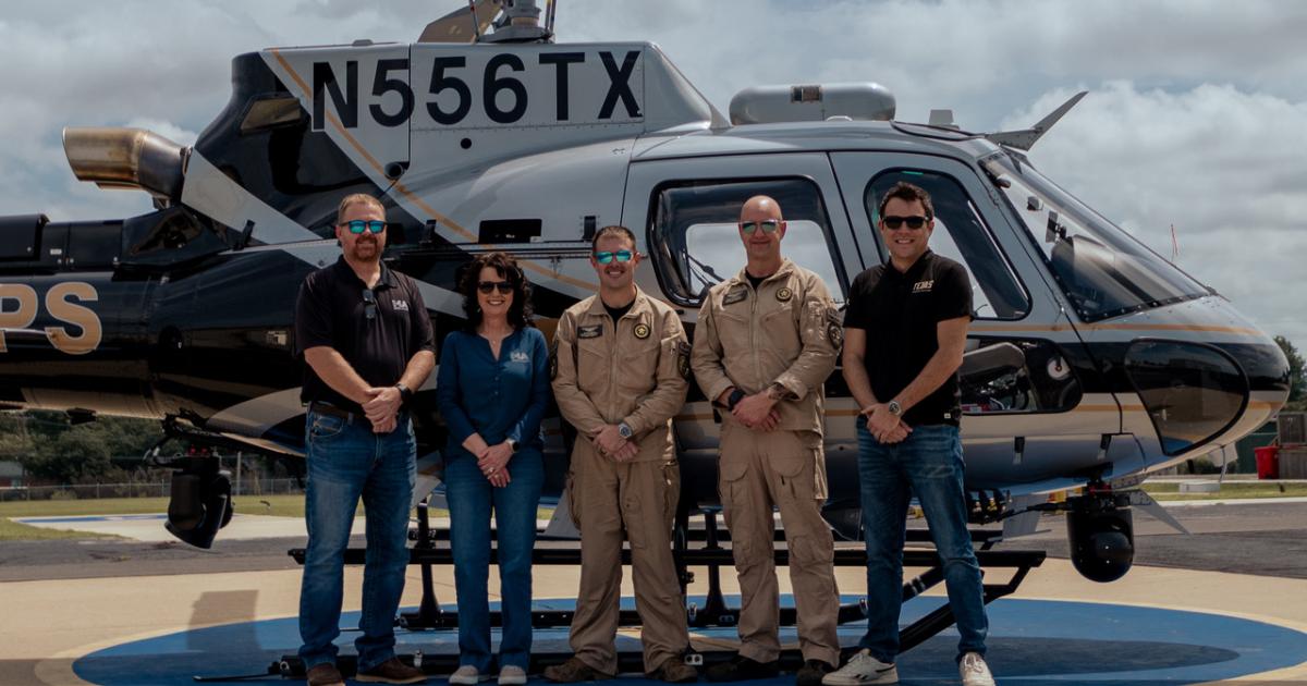 5 people standing by N-registered Airbus H125 