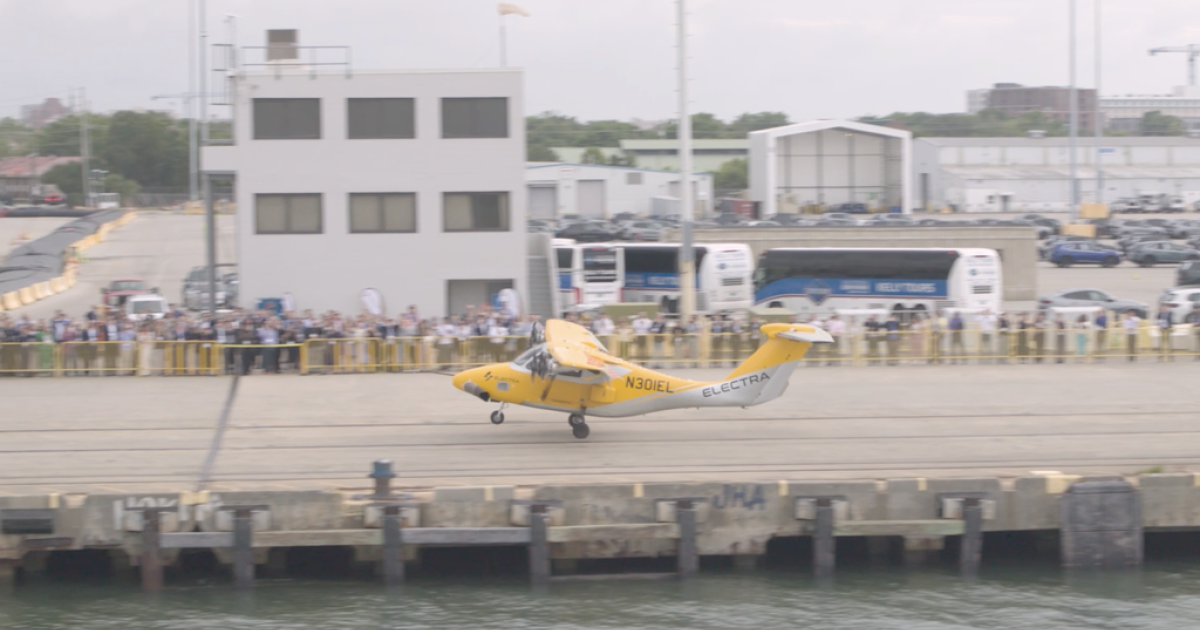 Electra EL2 landing on pier alongside crowd 