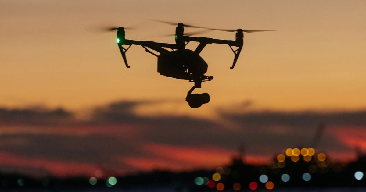 Drone flying over water at sunset 